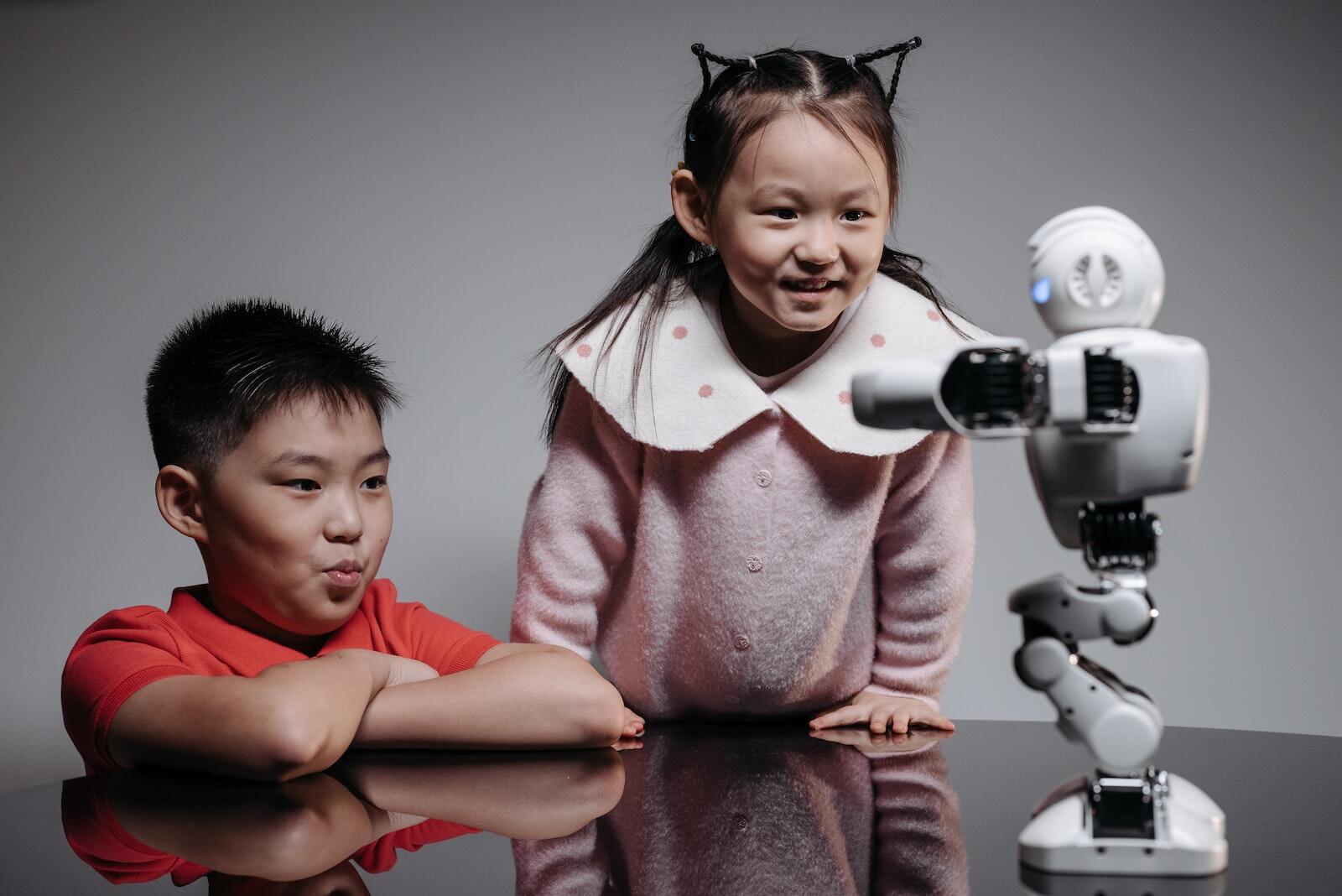 L'IA comme Compagnon de Vie - une Réalité Proche ? 1 A Young Girl and Boy Looking at the Robot on the Table