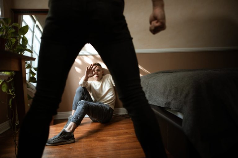 Woman in Black Pants and White Long Sleeve Shirt Lying on Brown Wooden Floor